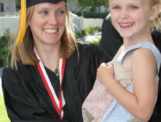 SBCC Single Parent Achievement Program: graduate with her daughter in her arms