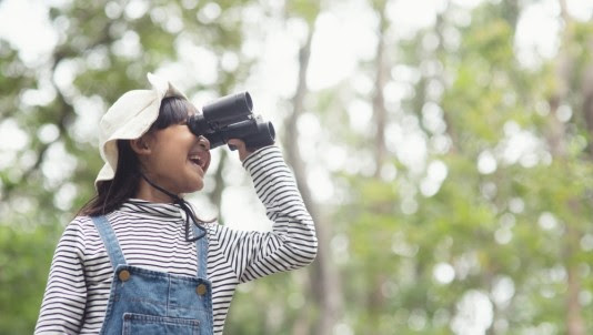 young girl looking through binoculars
