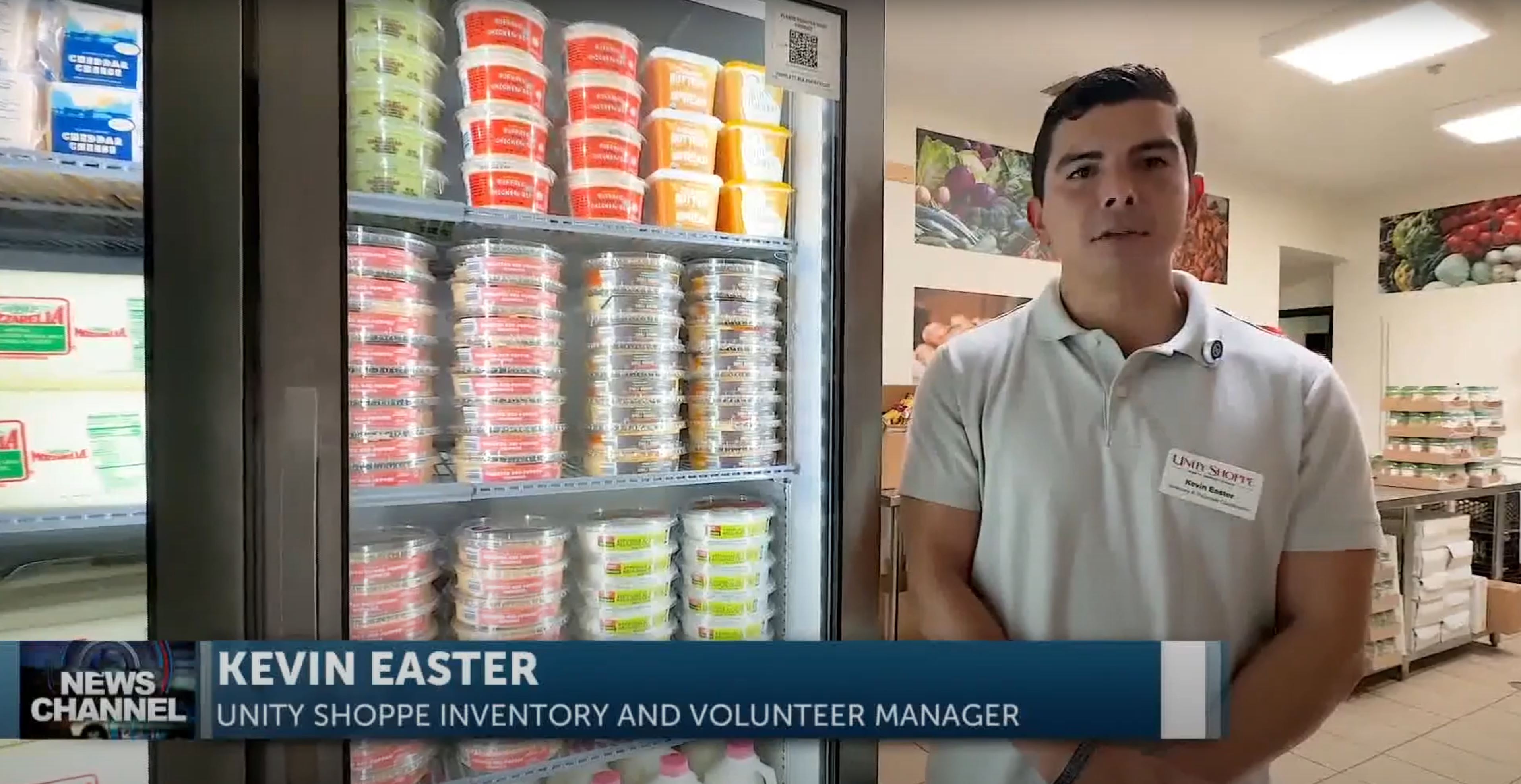 Kevin East of the Unity Shoppe stands in from of the new industrial refrigerator and freezers