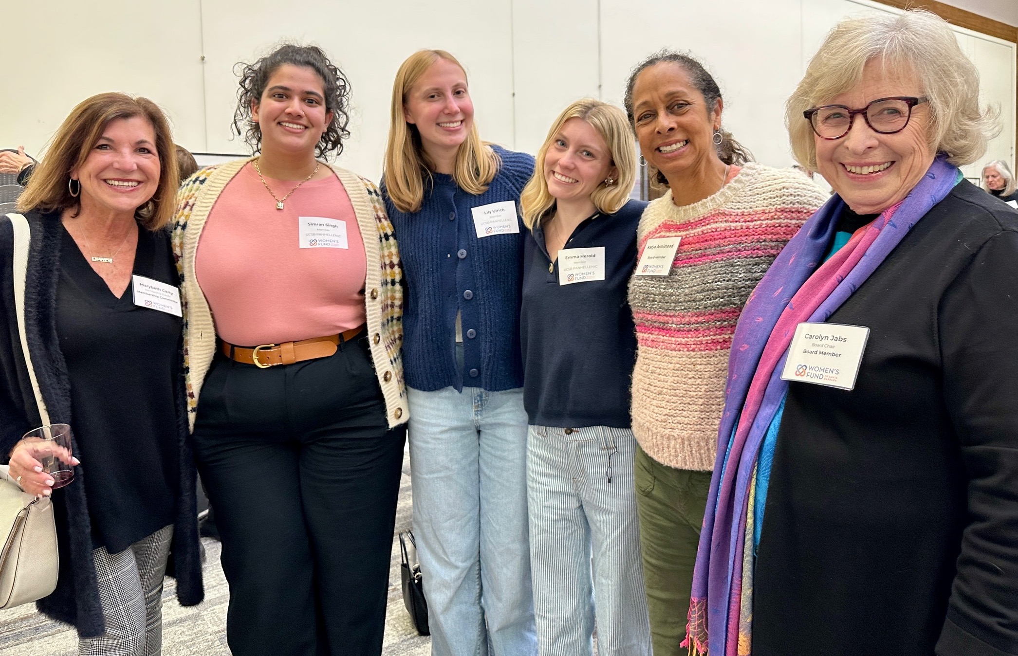 Six women from the Women's fund smile with linked arms