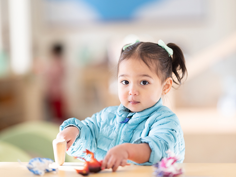 young girl playing with joys at table