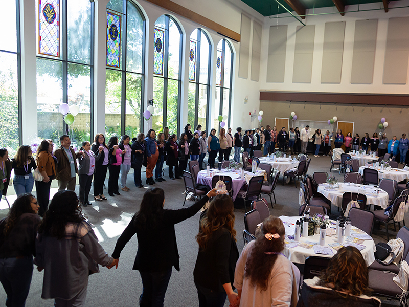 Caregiving training activities with large group of women in circle holding hands