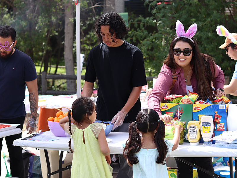 Adults serving food to children at Easter event
