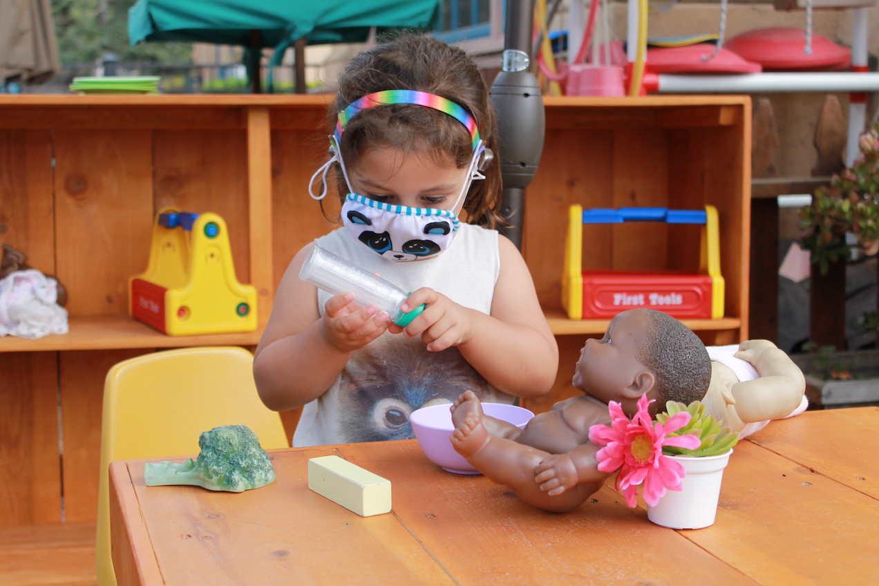 young girl plays with baby doll