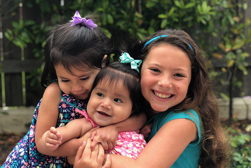 Three smiling, hugging girls