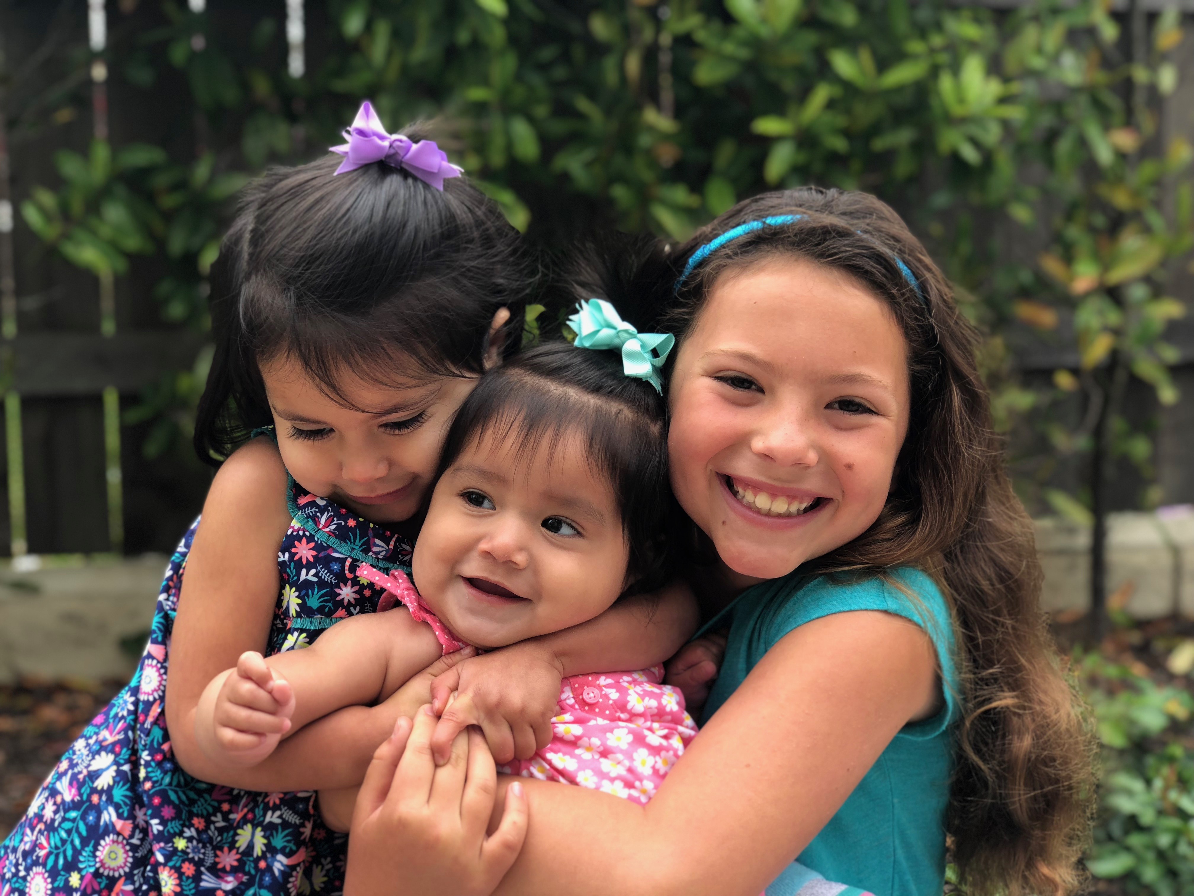 Three smiling, hugging girls
