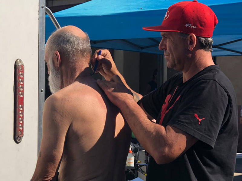 Man cuts another man's hair