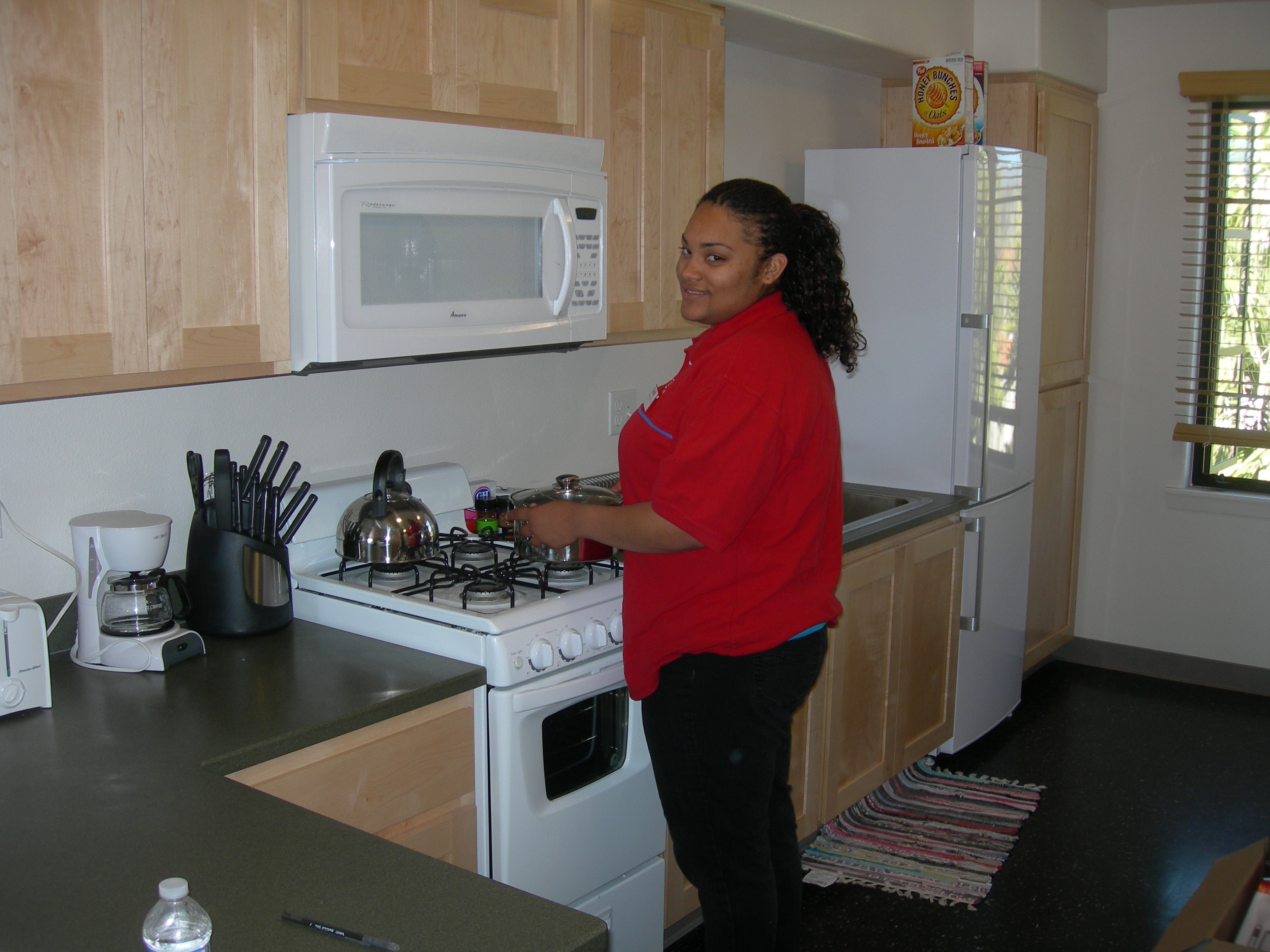 2010 Channel Islands YFS girl in red sweater in kitchenette