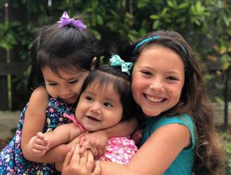 Three smiling, hugging girls
