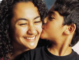 Young child kissing woman on the cheek