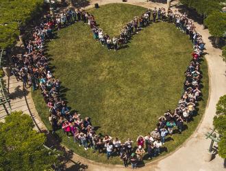 Aerial view of people standing forming a heart