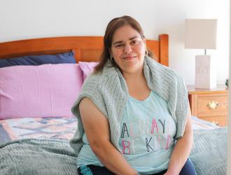 Woman sitting on bed smiling