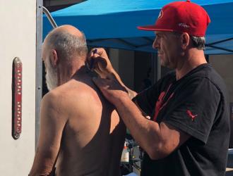 Man cuts another man's hair