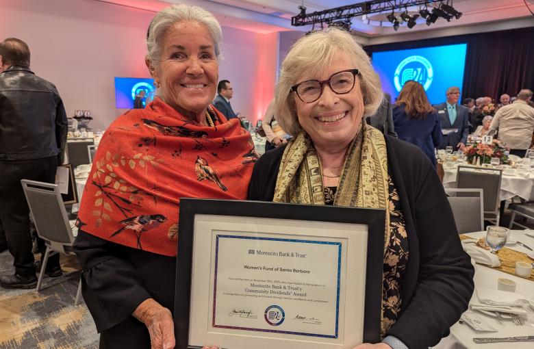 Suzi Schomer and Carolyn Jabs hold a framed Community Dividends certificate