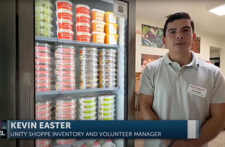 Kevin East of the Unity Shoppe stands in from of the new industrial refrigerator and freezers