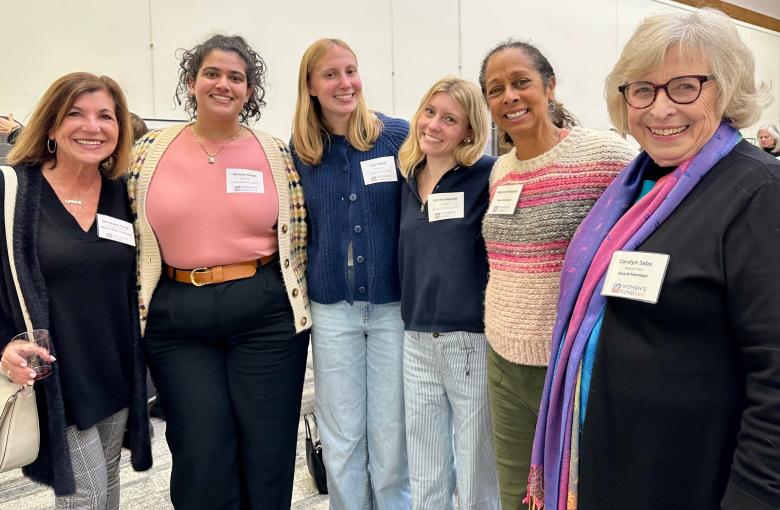 Six women from the Women's fund smile with linked arms