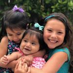 Three smiling, hugging girls
