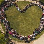 Aerial view of people standing forming a heart