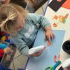 Little girl in blue playing with glue