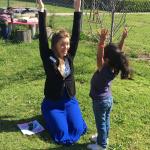 Counselor and girl with arms raised to the sky